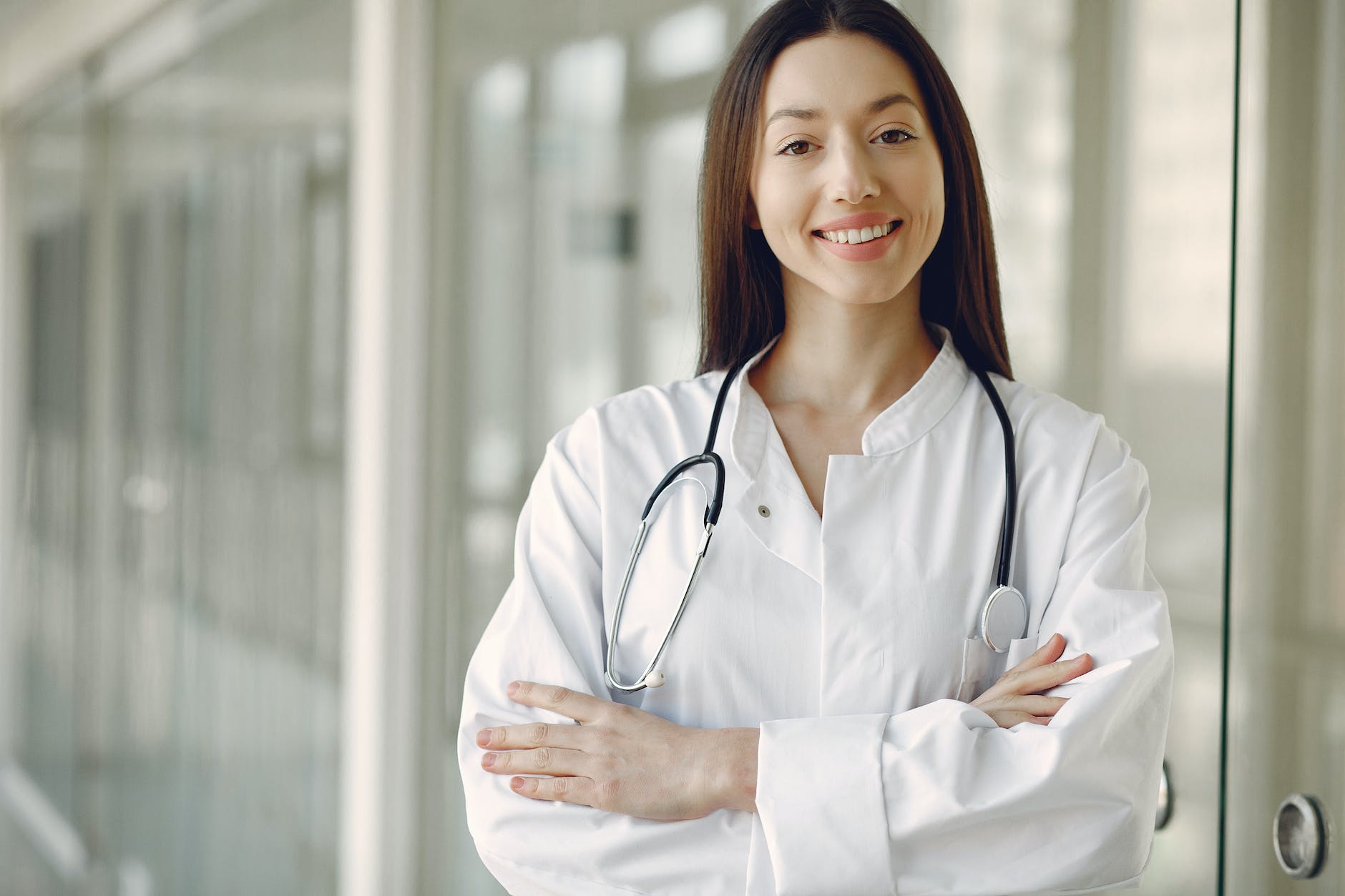 crop doctor in medical uniform with stethoscope standing in clinic corridor