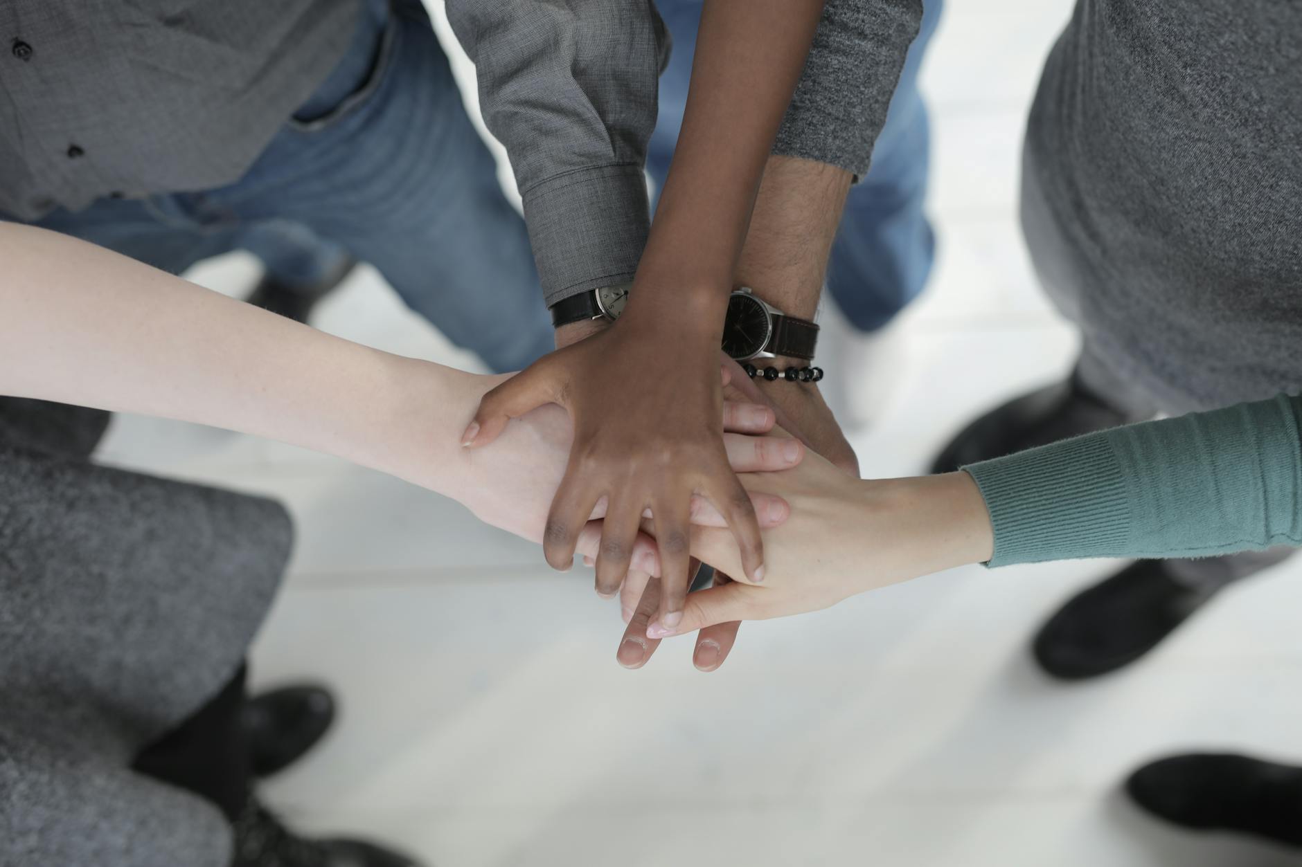 crop unrecognizable multiethnic colleagues joining hands